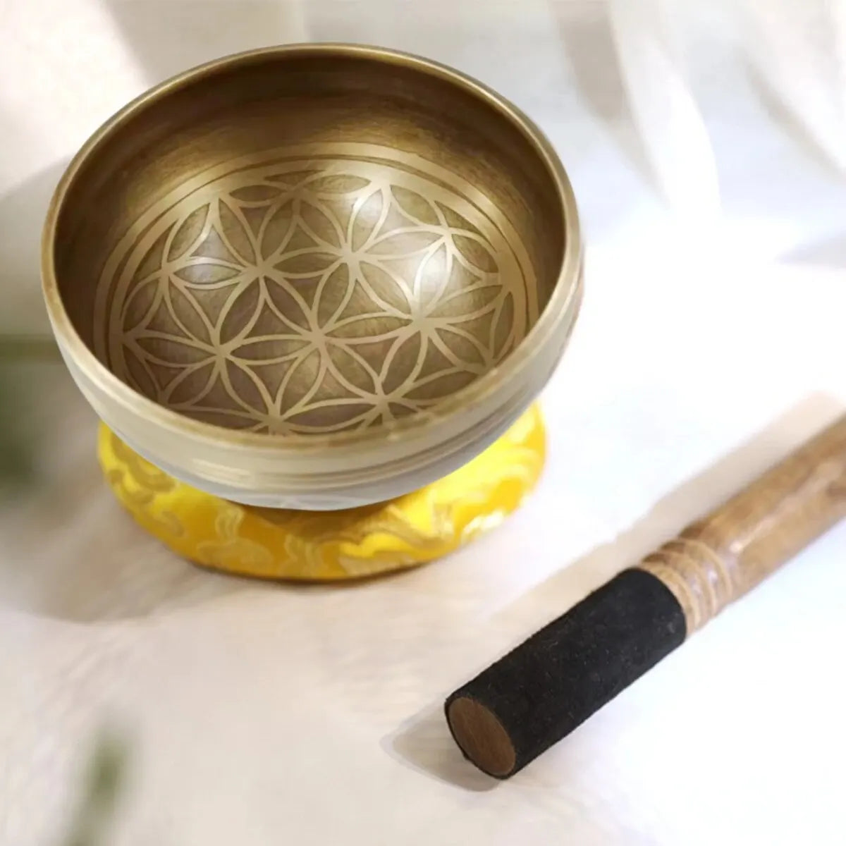 Bronze singing bowl with floral design on a white background