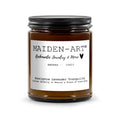 Brown candle jar with black lid and white label on a white background