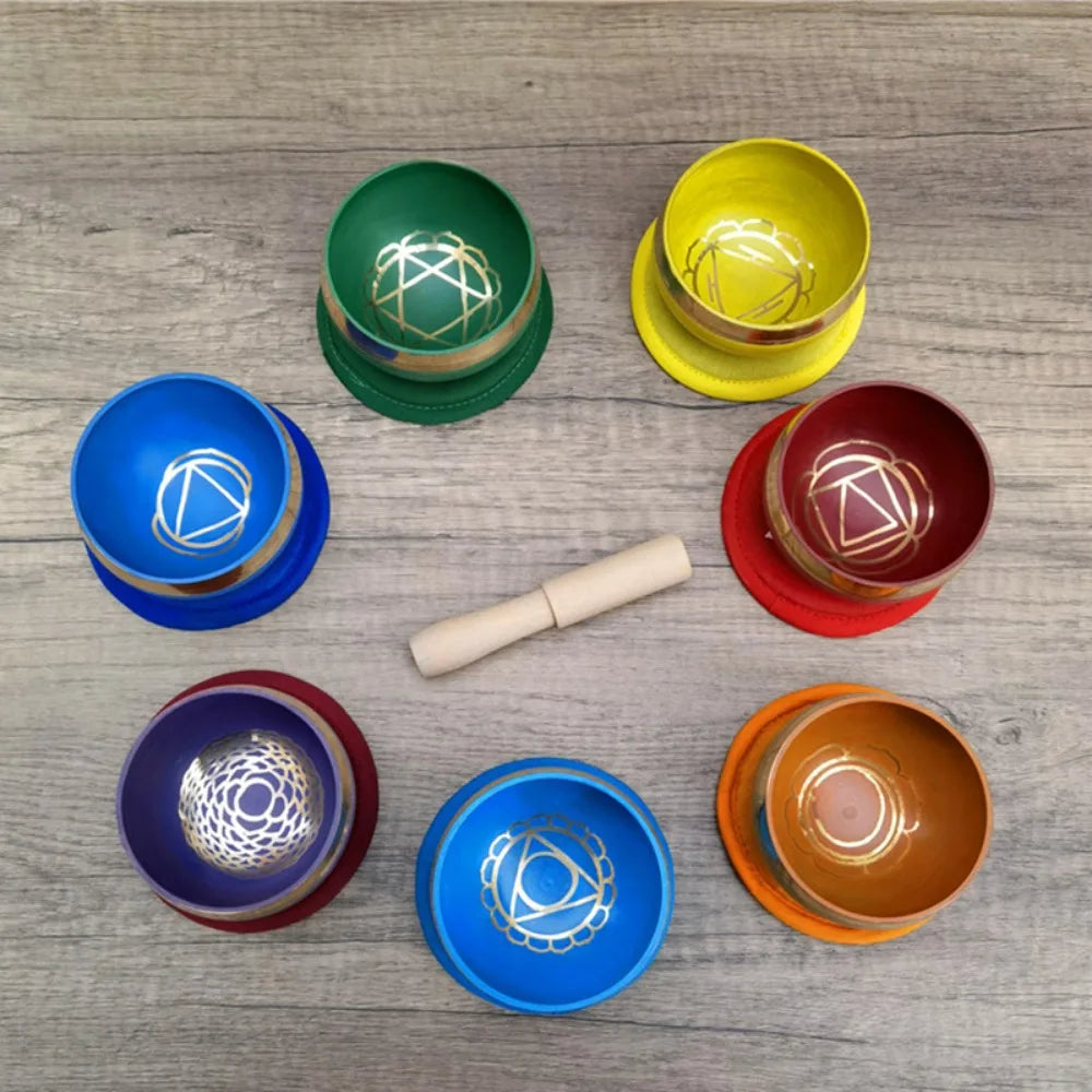Set of colorful singing bowls on a wooden surface