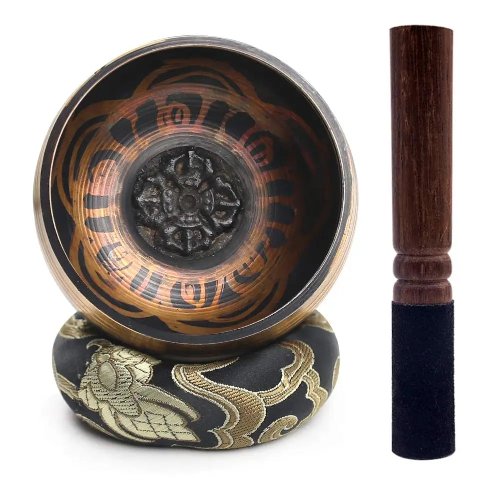 Tibetan singing bowl with decorative stand and wooden striker on a white background