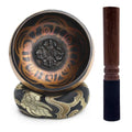 Tibetan singing bowl with decorative stand and wooden striker on a white background